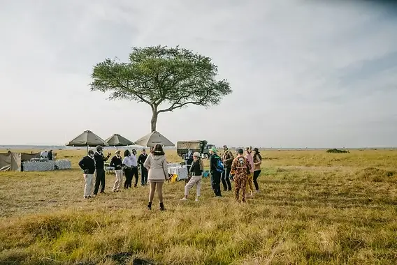 Couple on a private safari in Tanzania watching a leopard from their own 4x4 vehicle